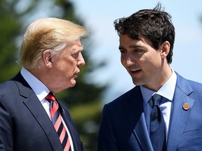 Prime Minister Justin Trudeau (R) speaks with U.S. President Donald Trump during the G7 official welcome at Le Manoir Richelieu on day one of the G7 meeting on June 8, 2018 in Quebec City.