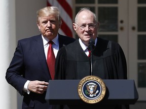 In this April 10, 2017, file photo, U.S. President Donald Trump, left, and Supreme Court Justice Anthony Kennedy participate in a public swearing-in ceremony for Justice Neil Gorsuch in the Rose Garden of the White House White House in Washington.