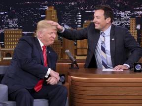 In this Sept. 15, 2016 image originally released by NBC, Republican presidential candidate Donald Trump appears with host Jimmy Fallon during a taping of "The Tonight Show Starring Jimmy Fallon," in New York.  Fallon is opening up about the personal anguish he felt following the backlash to his now-infamous hair mussing appearance with Donald Trump. Trump opponents criticized Fallon for a cringeworthy interview only weeks before the election where Fallon playfully stroked Trump's hair. (Andrew Lipovsky/NBC via AP, File) ORG XMIT: NYET322
