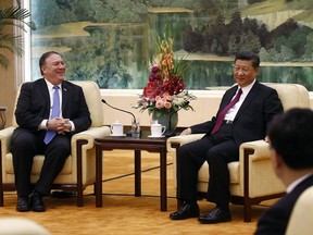 U.S. Secretary of State Mike Pompeo, left, shares a light moment with Chinese President Xi Jinping during their meeting at the Great Hall of the People in Beijing, Thursday, June 14, 2018. (AP Photo/Andy Wong)