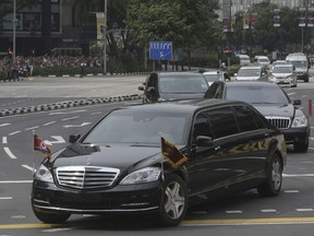 A limousine, front, with a North Korean flag believed to be carrying leader Kim Jong Un travels past Singapore's Orchard Road on its way to the St Regis Hotel as he arrives in Singapore on Sunday, June 10, 2018. (AP Photo/Joseph Nair)