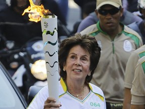 In this July 24, 2016 file photo the former No. 1-ranked tennis player Maria Esther Bueno carries the Rio 2016 Olympic torch during the torch relay in Sao Paulo, Brazil.