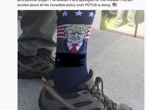 This screen shot posted Tuesday, June 26, 2018, on the official Twitter account of U.S. Interior Secretary Ryan Zinke shows him wearing socks with an image of President Trump and the campaign slogan "Make America Great Again," which has been blacked out on the photo, during an official event in Keystone, S.D. (U.S. Interior Department via AP)