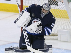Jets goalie Connor Hellebuyck makes a save during NHL action against the Blackhawks in Winnipeg on April 7, 2018.