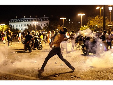 PARIS, FRANCE - JULY 15: French football fans clash with police following celebrations around the Arc de Triomph after France's victory against Croatia in the World Cup Final on July 15, 2018 in Paris, France. France beat Croatia 4-2 in the World Cup Final played at Moscow's Luzhniki Stadium today.