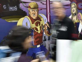 Attendees walk past cut-out figures of President Donald Trump and his daughter Ivanka at a booth for the satirical comic book series "Trump's Titans" during Preview Night of the 2018 Comic-Con International at the San Diego Convention Center, Wednesday, July 18, 2018, in San Diego. (Chris Pizzello/Invision/AP)