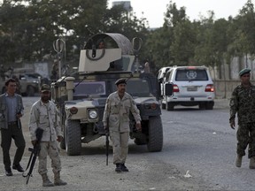 Security personnel patrol near the site of a deadly attack outside the Rural Rehabilitation and Development Ministry in Kabul, Afghanistan, Sunday, July 15, 2018. (AP Photo/Massoud Hossaini)