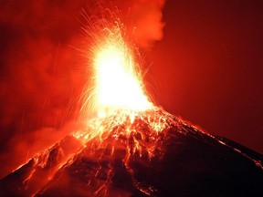 Ashes rises above as lava flows down the slopes of the Fuego volcano, 60KM from Guatemala City, on Jan. 9, 2004. (STR/Getty Images)