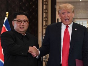 In this file photo taken on June 12, 2018 US President Donald Trump (R) and North Korea's leader Kim Jong Un shake hands following a signing ceremony during their historic US-North Korea summit, at the Capella Hotel on Sentosa island in Singapore.
