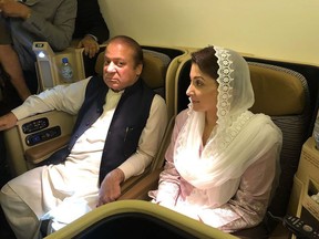 This handout photograph released by Pakistan Muslim League Nawaz (PML-N) party on July 14, 2018, show former prime minister Nawaz Sharif (L) and his daughter Maryam Nawaz siting on a plane after their arrival in Lahore.