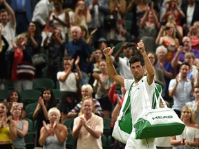 Novak Djokovic leaves the court after play was suspended against Rafael Nadal during their men's singles semi-final match on the eleventh day of the 2018 Wimbledon Championships at The All England Lawn Tennis Club in Wimbledon, southwest London, on July 13, 2018. (OLI SCARFF/AFP/Getty Images)