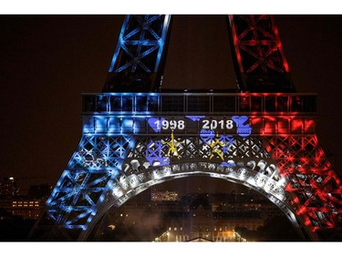 TOPSHOT - This picture taken from Trocadero on July 15, 2018 shows the Eiffel Tower illuminated in French national colors during celebrations after the Russia 2018 World Cup final football match between France and Croatia, on the Champs-Elysees avenue in Paris.  France beat Croatia 4-2.