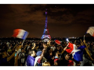 TOPSHOT - This picture taken from Trocadero on July 15, 2018 shows the Eiffel Tower illuminated in French national colors during celebrations after the Russia 2018 World Cup final football match between France and Croatia, on the Champs-Elysees avenue in Paris.
