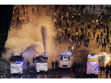 Police dispers people with water canons after celebrations following the Russia 2018 World Cup final football match between France and Croatia, on the Champs-Elysees avenue in Paris on July 15, 2018.  France won 4-2.