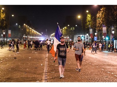 People walk after celebrations of the Russia 2018 World Cup final football match between France and Croatia, on the Champs-Elysees avenue in Paris on July 15, 2018.