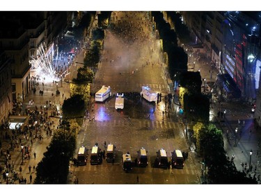 This picture taken from the top of the Arch of Triumph (Arc de Triomphe) on July 15, 2018 shows security forces working to contain clashes following celebrations of the Russia 2018 World Cup final football match between France and Croatia, on the Champs-Elysees avenue in Paris.