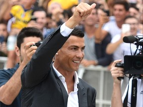 Portuguese attacker Cristiano Ronaldo gives the thumb up as he arrives on July 16, at the Juventus medical center at the Alliance stadium in Turin. (Miguel Medina/Getty Images)