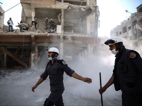 Syrian civil defence volunteers, known as the White Helmets, work around destroyed buildings following reported air strikes on the rebel-held town of Douma, on the eastern outskirts of the capital Damascus, on Oct. 5, 2016. (Sameer Al-Doumy/Getty Images)