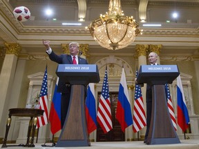 U.S. President Donald Trump, left, tosses a soccer ball to his wife first lady Melania Trump after Russian President Vladimir Putin presented it to him during a press conference after their meeting at the Presidential Palace in Helsinki, Finland, Monday, July 16, 2018.