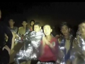 In this July 3, 2018, image taken from video provided by the Thai Navy Seal, Thai boys are with Navy SEALs inside the cave, Mae Sai, northern Thailand. (Thai Navy Seal via AP)