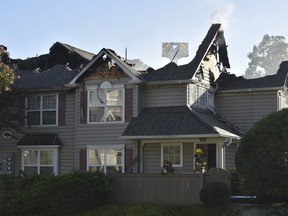 Two firefighters walk out of an apartment building as authorities respond to an aviation crash at the structure, possibly involving a helicopter, Sunday, July 8, 2018, in Williamsburg, Va. (AP Photo/Nickolas Oatley)