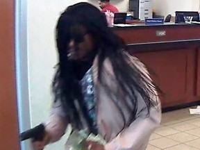 An image from video provided by the Durham Police Department shows a suspect in the robbery of a Durham, N.C., bank Wednesday, July 18, 2018. Police in North Carolina say a bank robber shot and wounded a teller before getting away with money. (Durham Police Department via AP) ORG XMIT: NYDB402