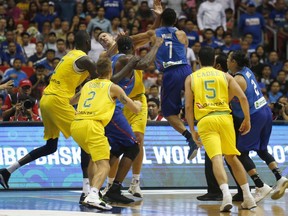 In this  July 2, 2018, file photo, Philippines' Jason William (7) jumps to hit Australia's Daniel Kickert as others rush in during FIBA World Cup qualifying at the Philippine Arena.
