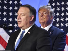 U.S. President Donald Trump, right, listens to U.S. Secretary of State Mike Pompeo during press conference after a summit of heads of state and government at NATO headquarters in Brussels, Belgium, Thursday, July 12, 2018. (AP Photo/Geert Vanden Wijingaert)