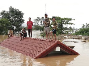 Villagers take refuge on a rooftop above flood waters from a collapsed dam in the Attapeu district of southeastern Laos, Tuesday, July 24, 2018. (Attapeu Today via AP)