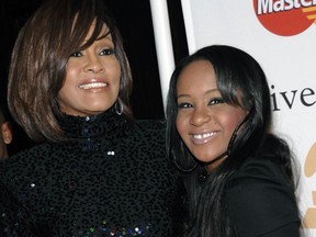 FILE - In this Feb. 12, 2011, file photo, singer Whitney Houston, left, and daughter Bobbi Kristina Brown arrive at an event in Beverly Hills, Calif. Singer Bobby Brown will receive a proclamation to build a domestic violence shelter in Atlanta in honor of his late daughter, Bobbi Kristina Brown. Bobbi Kristina died in hospice care July 26, 2015, about six months after she was found face-down and unresponsive in a bathtub in her suburban Atlanta townhome. Her former boyfriend, Nick Gordon was found responsible in a wrongful death lawsuit.