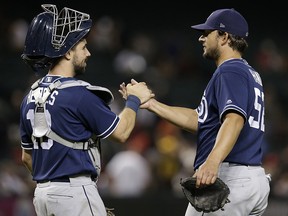 San Diego Padres pitcher Brad Hand (52) and Austin Hedges celebrate after defeating the Arizona Diamondbacks Sunday, July 8, 2018, in Phoenix. (AP Photo/Rick Scuteri)