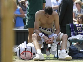 John Isner of the United States sits after losing the first set against South Africa's Kevin Anderson at Wimbledon in London, Friday July 13, 2018.