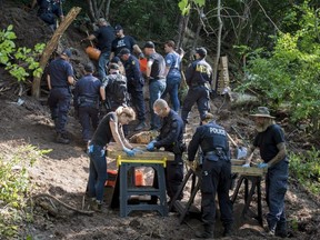 Members of the Toronto Police Service sift and excavate materials from the back of property along Mallory Cres. in Toronto after confirming they have found human remains during an investigation in relation to alleged serial killer Bruce McArthur on Thursday, July 5, 2018. THE CANADIAN PRESS/Tijana Martin