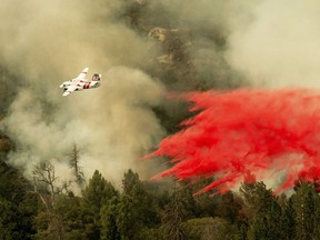 An air tanker drops retardant while fighting to stop the Ferguson Fire from reaching homes in the Darrah community of unincorporated Mariposa Count, Calif., Wednesday, July 25, 2018.