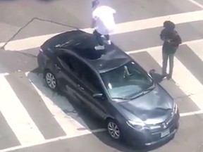 Video posted to social media of a man jumping on top of a car at Richmond and Peter Sts. in downtown Toronto on Monday.