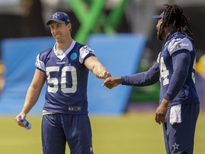 Dallas Cowboys linebacker Sean Lee (50) fist bumps teammate linebacker Jaylon Smith, right, during NFL training camp, Friday, July 27, 2018, in Oxnard, Calif.