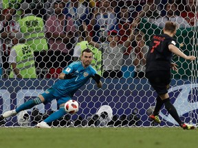 Croatia's midfielder Ivan Rakitic (R) scores his penalty past Russia's goalkeeper Igor Akinfeev during the Russia 2018 World Cup quarter-final football match between Russia and Croatia at the Fisht Stadium in Sochi on July 7, 2018.