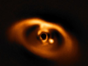 The photo provided by the European Southern Observatory ESO taken from the SPHERE instrument on ESO's Very Large Telescope is the first clear image of a planet caught in the very act of formation around the dwarf star PDS 70. The planet stands clearly out, visible as a bright point to the right of the centre of the image, which is blacked out by the coronagraph mask used to block the blinding light of the central star. (ESO via AP)