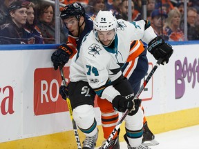 Edmonton's Connor McDavid is hit by San Jose's Dylan DeMelo during the first period of a NHL game at Rogers Place between the Edmonton Oilers and the San Jose Sharks in Edmonton on Dec. 18, 2017.