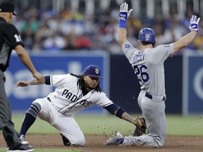 San Diego Padres shortstop Freddy Galvis, left, tags out the Los Angeles Dodgers' Chase Utley on a steal attempt during the third inning of a baseball game Thursday, July 12, 2018, in San Diego.