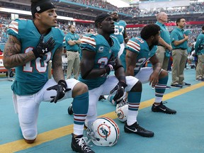 In this Sunday, Oct. 23, 2016, file photo, Miami Dolphins wide receiver Kenny Stills (10), free safety Michael Thomas (31) and defensive back Chris Culliver (29) kneel during the anthem in Miami Gardens, Fla. (AP Photo/Wilfredo Lee, File)