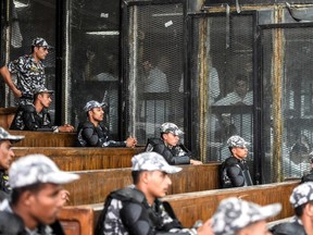 Members of Egypt's banned Muslim Brotherhood are seen inside a glass dock during their trial in Cairo on Saturday, July 28, 2018.