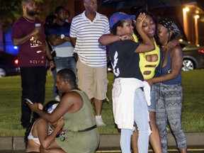 People react at the scene of a shooting in New Orleans, Saturday night, July 28, 2018.