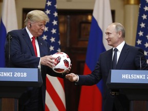 Russian President Vladimir Putin gives a soccer ball to U.S. President Donald Trump, left, during a press conference after their meeting at the Presidential Palace in Helsinki, Finland, Monday, July 16, 2018.