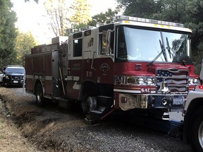 This Saturday, July 14, 2018, photo released by Sacramento Metro Fire shows a stolen fire truck stopped after a wild chase in Calif., in the Yankee Hill community of Butte County, Calif. (Chris Vestal/Sacramento Metro Fire via AP)