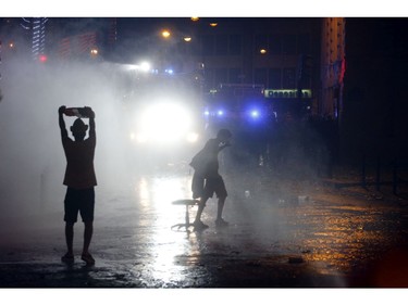 Demonstrators confront riot police during clashes on the Champs Elysees avenue where soccer fans celebrate France's World Cup victory over Croatia in Paris, France , Sunday, July 15, 2018 in Paris. France won its second World Cup title by beating Croatia 4-2.