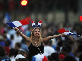 A woman waves French flag on the Champs Elysees avenue after France won the soccer World Cup final match between France and Croatia, Sunday, July 15, 2018 in Paris.