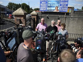 Former Sinn Fein president Gerry Adams, centre right stands the Sinn Fein members Bobby Storey, background left, Gerry Kelly, background and Carál Ní Chuilín during a press conference at Connolly House in Belfast, Northern Ireland, Saturday July 14, 2018. (Brian Lawless/PA via AP)