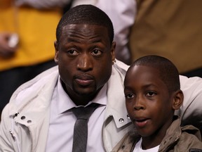 Dwyane Wade of the Miami Heat and son Zaire watch the action between the Los Angeles Lakers and the Boston Celtics during Game Five of the 2010 NBA Finals on June 13, 2010 at TD Garden in Boston, Massachusetts. (Elsa/Getty Images)