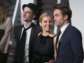 Tom Sturridge, left, Sienna Miller, centre, and Robert Pattinson, right, arrive to the 2015 Vanity Fair Oscar Party Feb. 22, 2015 in Beverly Hills, Calif. (ADRIAN SANCHEZ-GONZALEZ/AFP/Getty Images)